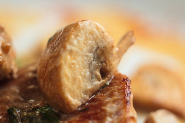 Concept: restaurant menus, healthy eating, homemade, gourmands, gluttony. White plate of pork medallions with mushroom sauce on weathered wooden table. Detail