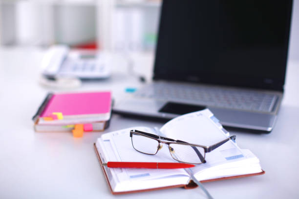 istock A note book, laptop, pen, graph paper document on the office desk table behind white blind 644300498