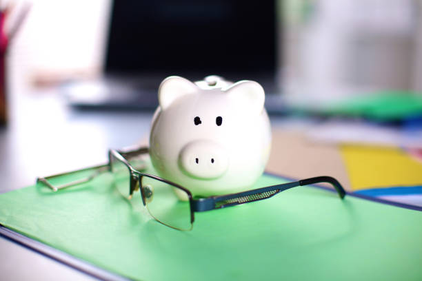 istock Office workplace with money box and glasses on wood table 644303102