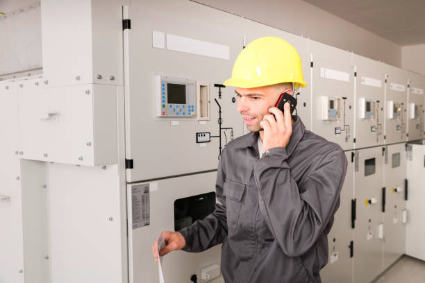 istock Electrician Consulting Experts Using Phone For Repairing Power Station 644305094