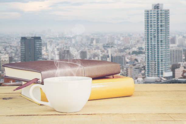 Hot coffee and book on wood table background Tokyo city Japan with copy space. concept picture.