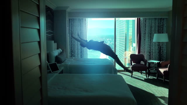 Two videos of man jumping on the bed in real slow motion