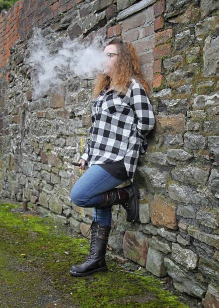 istock young woman smoking electronic cigarette, vaping 644346958