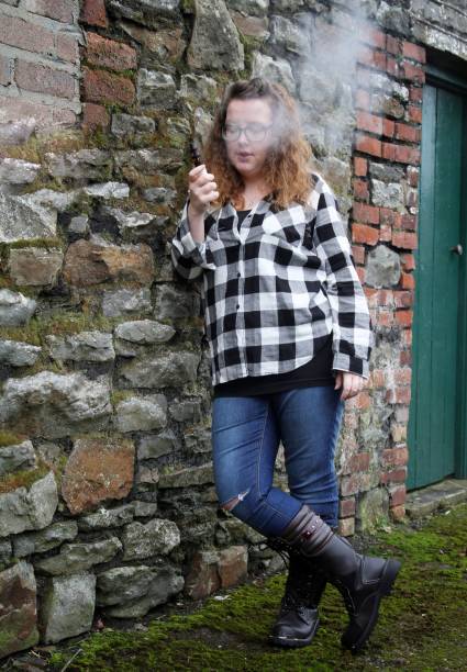 young woman smoking electronic cigarette, vaping