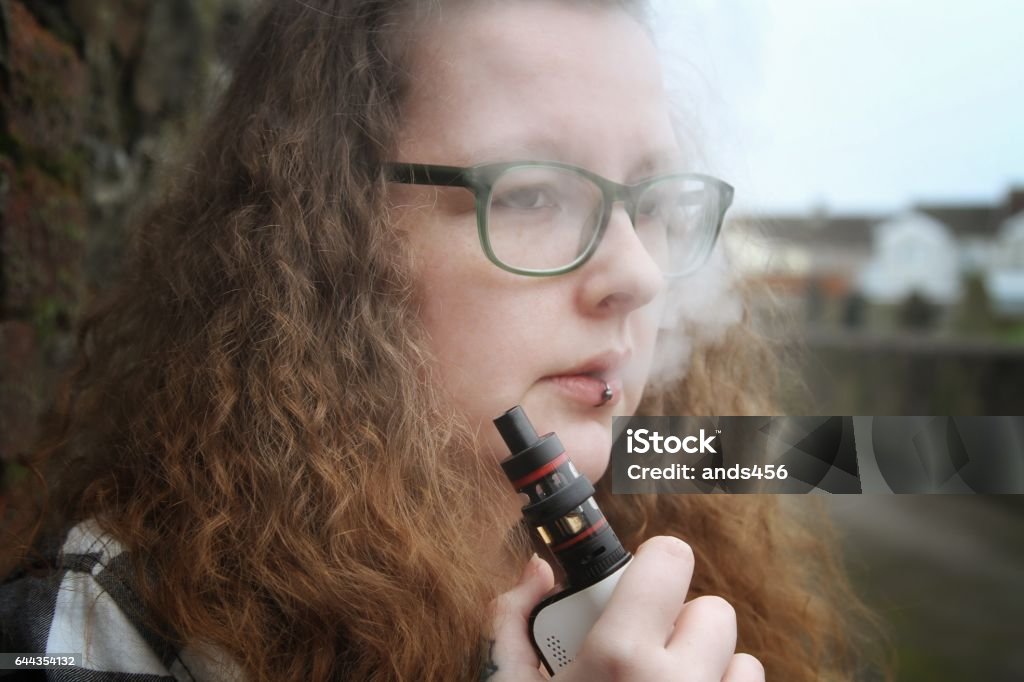 young woman smoking electronic cigarette, vaping Electronic Cigarette Stock Photo