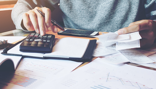 Hombre usando calculadora y calcular facturas en la oficina en casa. photo