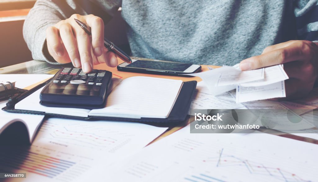 Hombre usando calculadora y calcular facturas en la oficina en casa. - Foto de stock de Formulario de impuestos libre de derechos