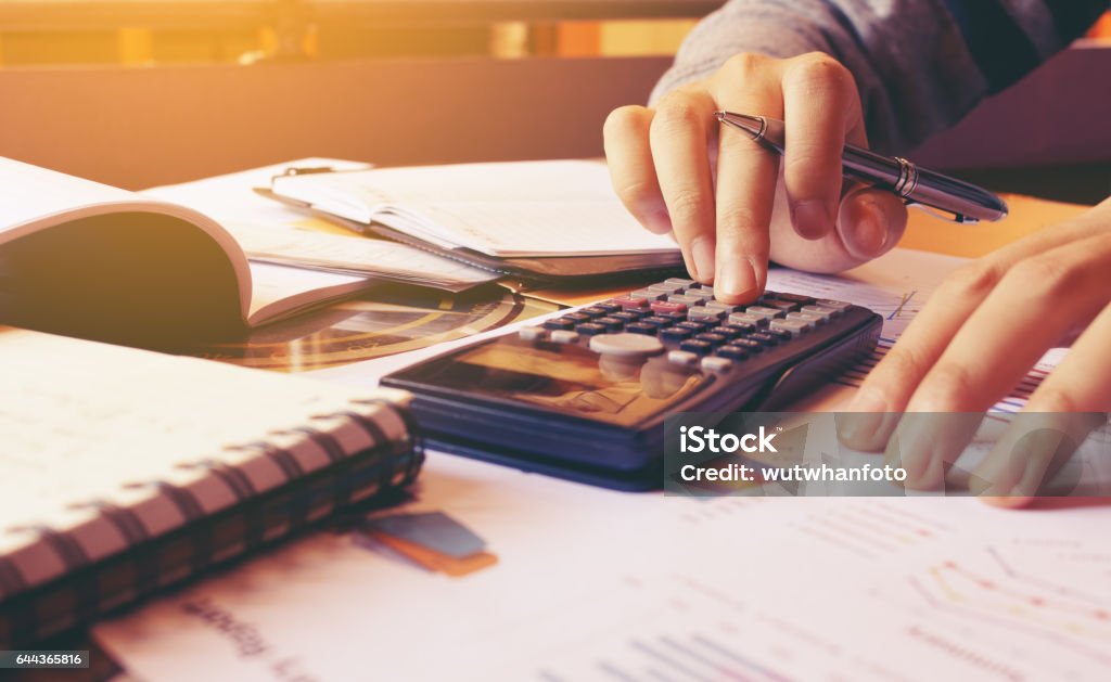 Woman using calculator with doing finance at home office. Accountancy Stock Photo