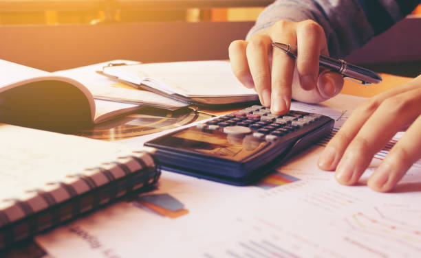 woman using calculator with doing finance at home office. - tax financial figures analyzing banking document imagens e fotografias de stock