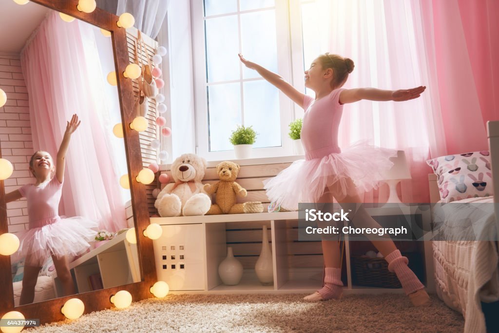girl dreams of becoming a ballerina Cute little girl dreams of becoming a ballerina. Child in a pink tutu dancing in a kids room. Child Stock Photo