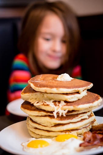 a smile at a stack of pancakes