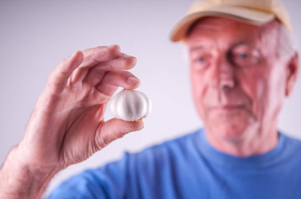 istock Farmer holding, garlic, senior man 644388014