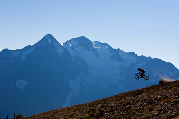 남성 산악 자전거 라이더는 하루의 끝에 내리막 길에 점프를 명 중 한다. - 5576 뉴스 사진 이미지