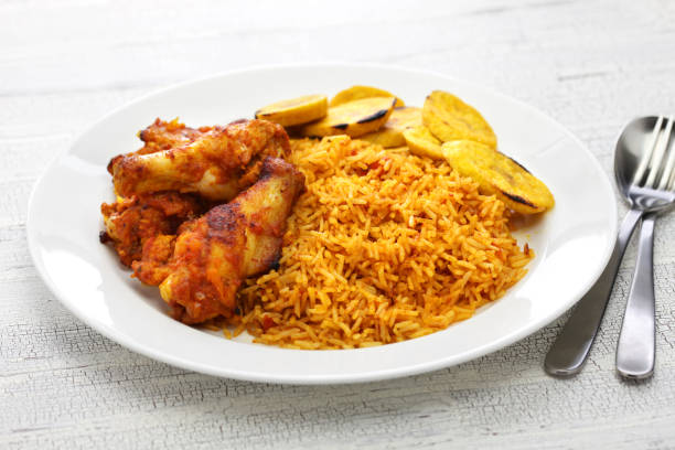 riz jollof avec du poulet et des plantains frits, cuisine afrique de l’ouest - nutmeg pepper nobody spice photos et images de collection
