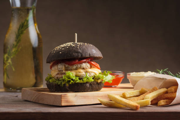 istock Trendy burger with chicken in black bun 644432056