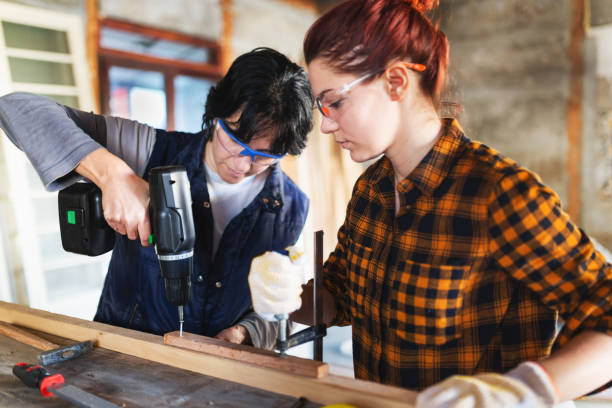 istock Female carpenter screwing her work together 644432342