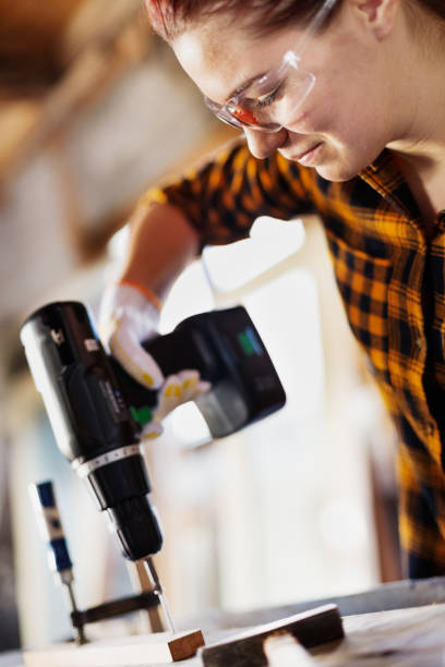 istock Female carpenter screwing her work together 644444686