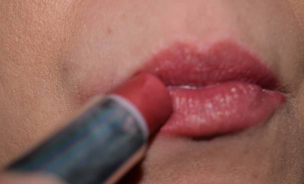 istock applying lipstick to lips mouth make up 644462436