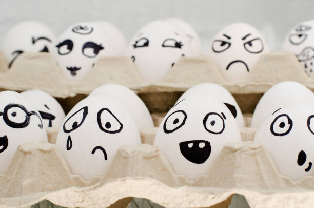 istock Eggs in tray painted with different emotions: sadness, surprise, amazement. Close-up 644463282