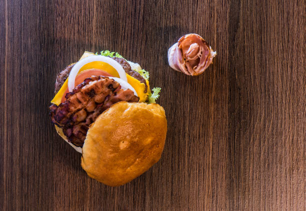 Top view of tasty bacon hamburger and all its ingredients
