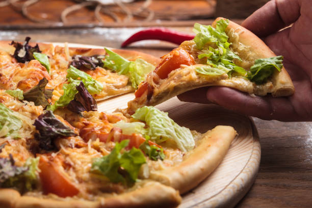 istock Caesar pizza on messy wooden background. 644512208