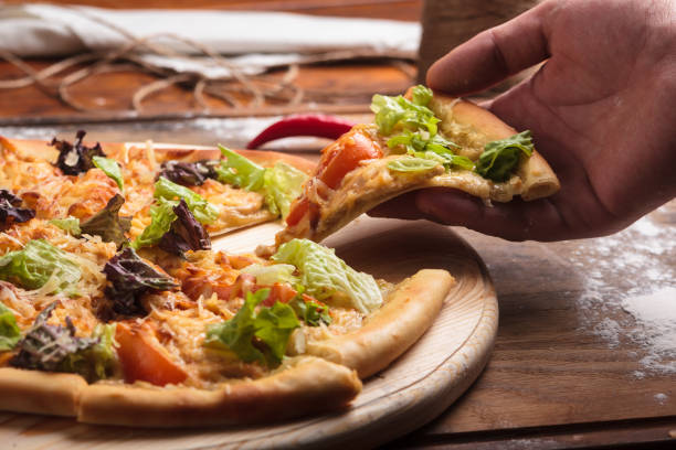 istock Caesar pizza on messy wooden background. 644512528