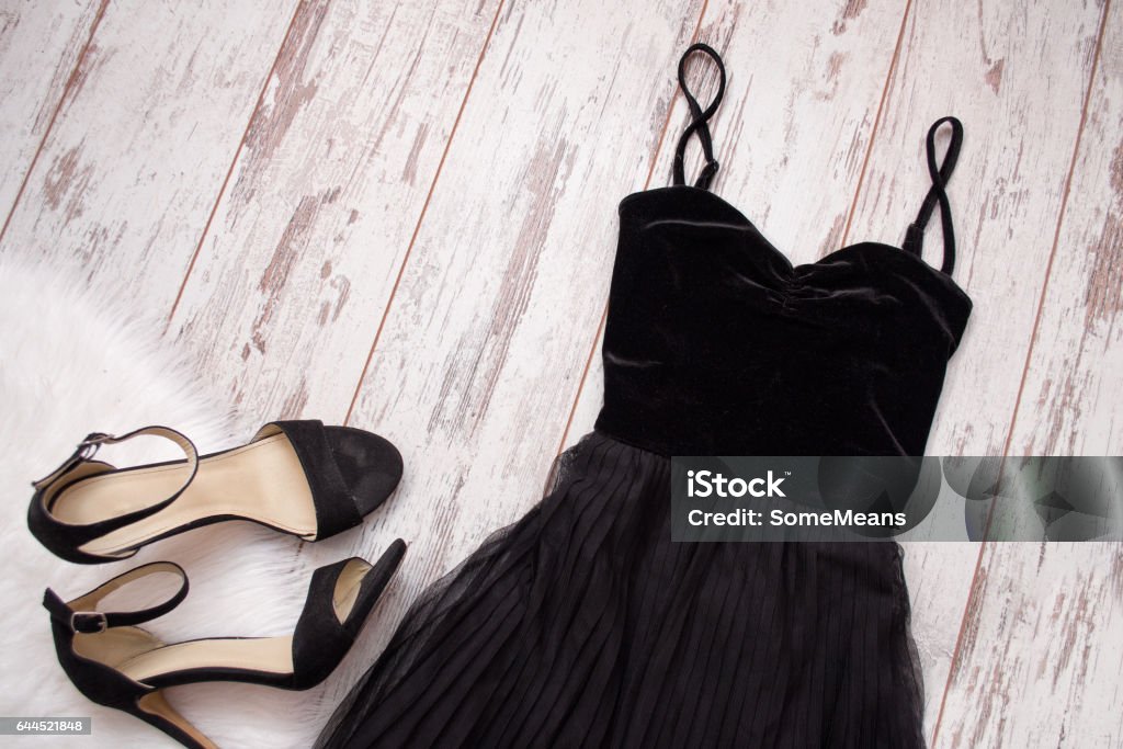 Black evening dress and shoes on a wooden background. Fashion concept. Top view, space for text Black Color Stock Photo