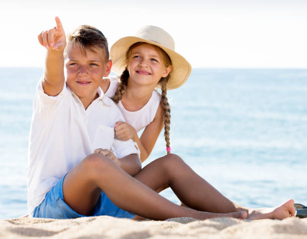 istock Children pointing with finger on sandy beach 644532236