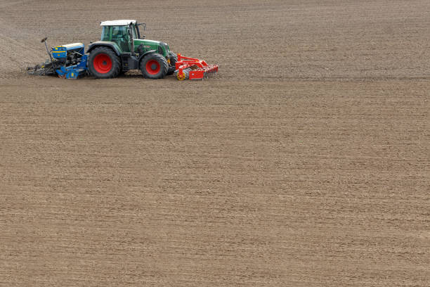Farmer seeding crops at field in spring