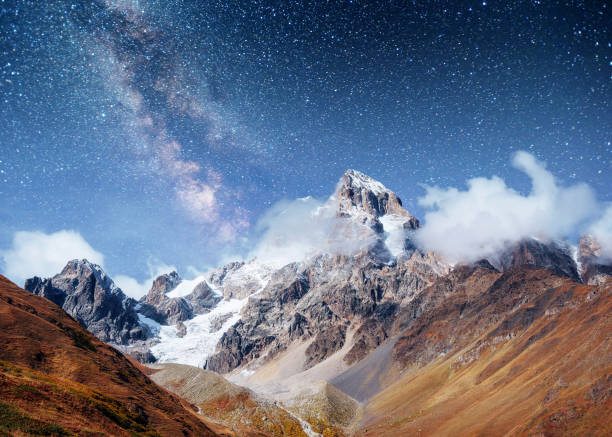 istock Fantastic starry sky. Autumn landscape and snow-capped peaks. Ma 644581758
