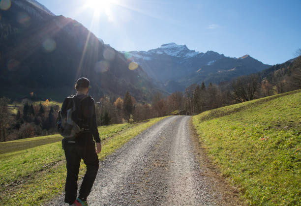 istock Hiker wanders up road into mountains and sun 644595781
