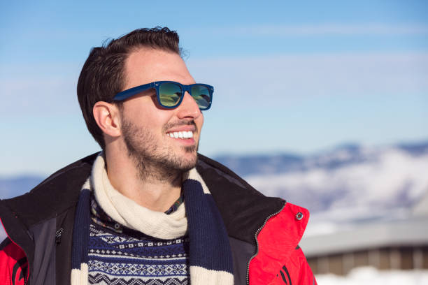 Male portrait on blue sky background on winter.