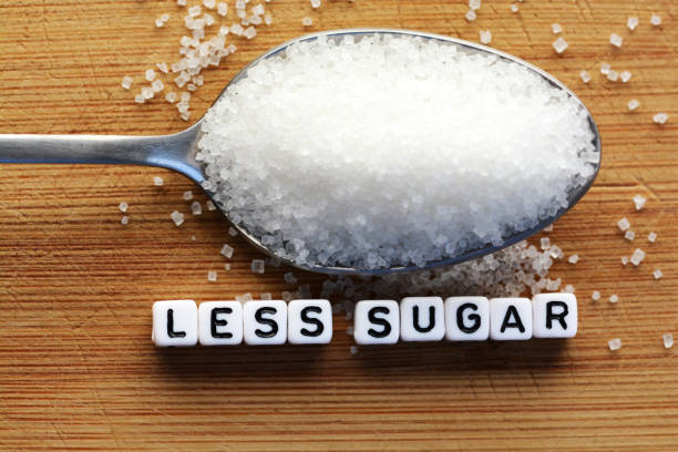 istock Less sugar text from tiled letter blocks and sugar pile on a spoon suggesting dieting concept 644611074