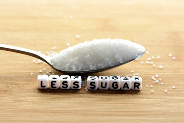 istock Less sugar text from tiled letter blocks and sugar pile on a spoon suggesting dieting concept 644611706