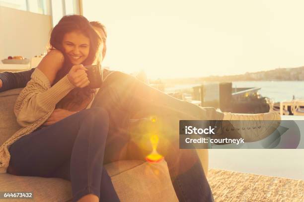 Couple On The Sofa At Sunrise Stock Photo - Download Image Now - Men, Tickling, Women