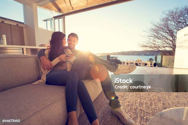 Couple On The Sofa At Sunrise Stock Photo - Download Image Now - Luxury, Couple - Relationship, Wealth