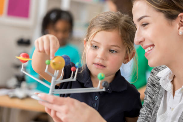 istock Cheerful teacher teaches child about astronomy 644681900