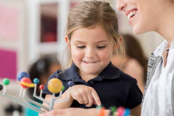 istock Happy girl learns about astronomy in science class 644681986