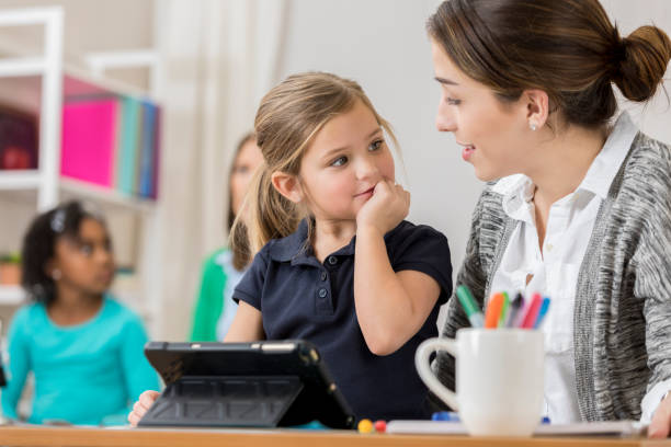 istock Attentive schoolgirl listens to teacher during class 644682042