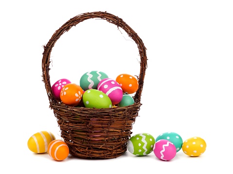 Easter basket filled with colorful hand painted Easter Eggs over a white background