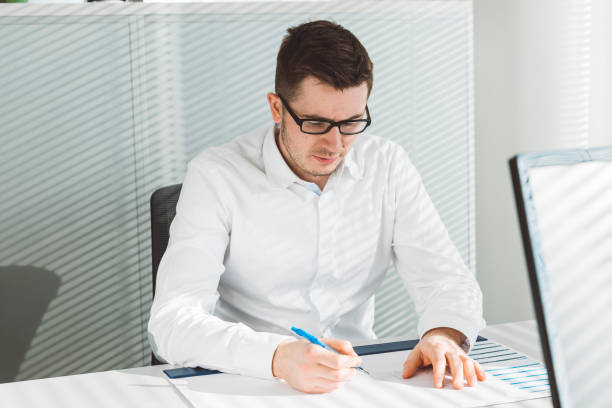 istock Employee in a white shirt writing down a note 644707352