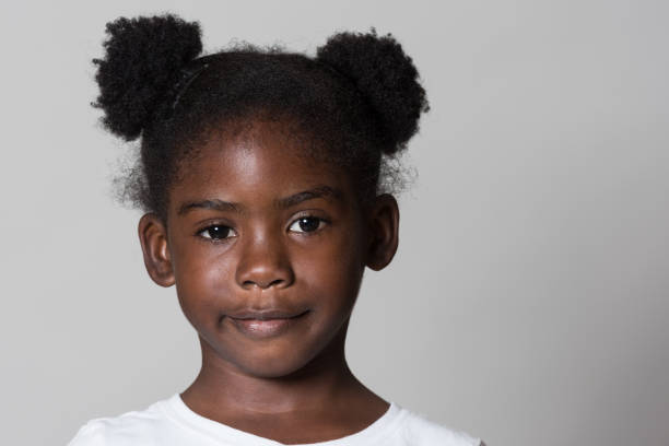 african descent little girl posing on gray background