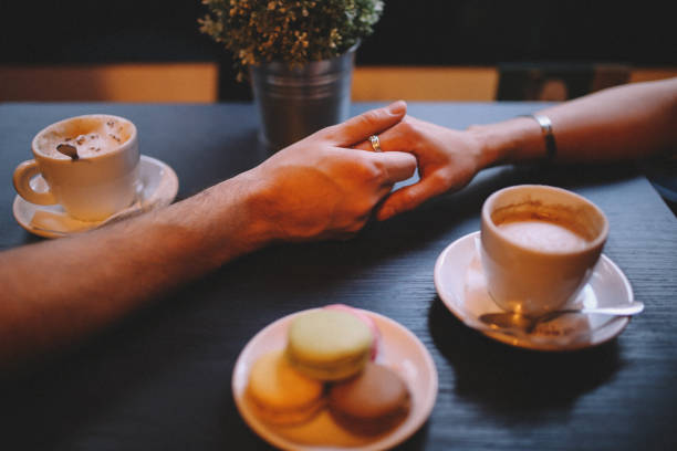 istock Young couple holding hands in the cafe 644832128