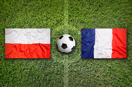 Poland vs. France flags on green soccer field