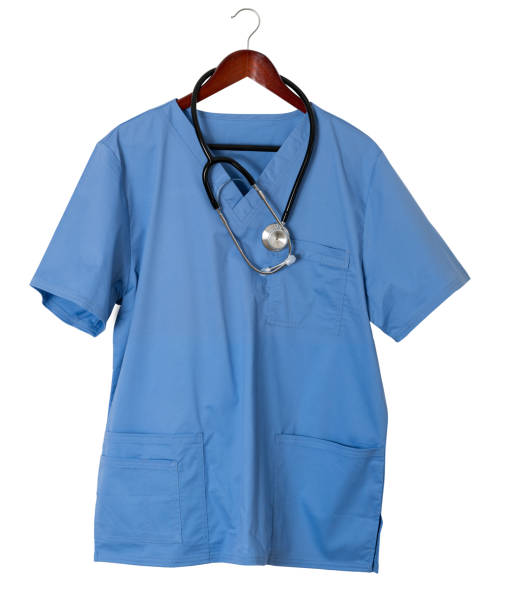 Blue scrubs shirt for medical professional hanging on door stock photo