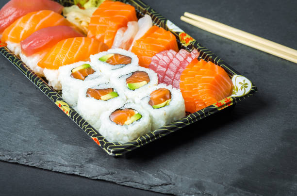 istock Sushi and Sashimi rolls on a black stone slatter 644892534