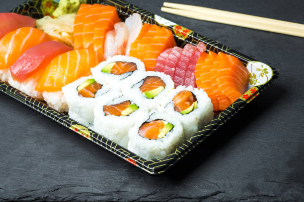 istock Sushi and Sashimi rolls on a black stone slatter 644896452