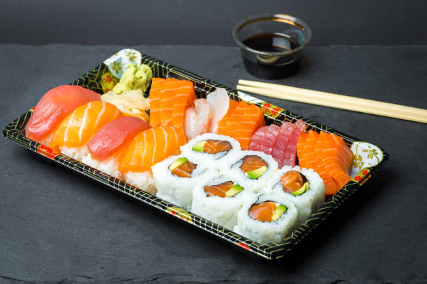 istock Sushi and Sashimi rolls on a black stone slatter 644899408