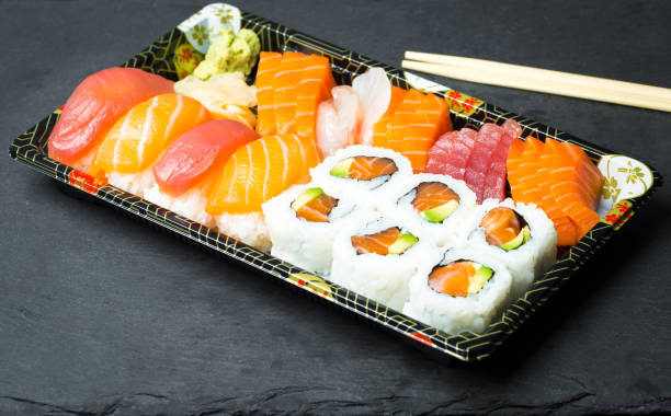 istock Sushi and Sashimi rolls on a black stone slatter 644903684