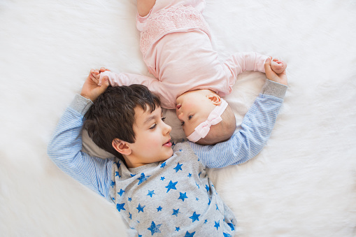 An image of a two little boys, ages five and three, with their newborn brother.